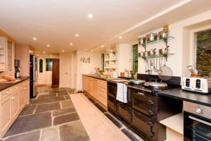 a large kitchen with black counters and a large island at Ladye Park in Liskeard