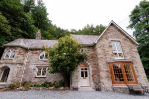 a stone house with a tree in front of it at Ladye Park in Liskeard