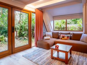 una sala de estar con un sofá y una mesa en Boshuisje Rekem - Sylva, en Lanaken