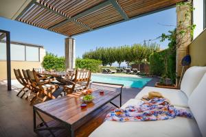a patio with a table and chairs and a pool at Sunny Exclusive Tria in Hanioti