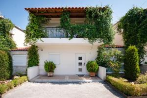 una casa bianca con piante sulla facciata di Sunny Exclusive Ena a Hanioti