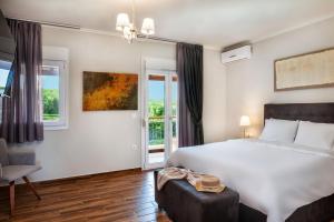 una camera da letto con un grande letto bianco e una finestra di Sunny Exclusive Ena a Hanioti Altre 26 foto