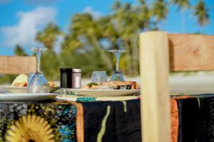 ein Tisch mit Tellern mit Essen und Weingläsern darauf in der Unterkunft Quiet beachfront hideaway - Mafia Island - 2355 in Bweni