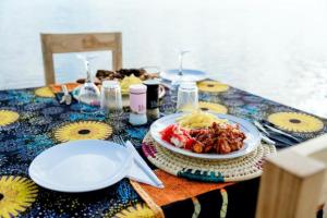 ein Tisch mit einem Teller mit Essen auf einem Tisch in der Unterkunft Quiet beachfront hideaway - Mafia Island - 2355 in Bweni + 38 Fotos