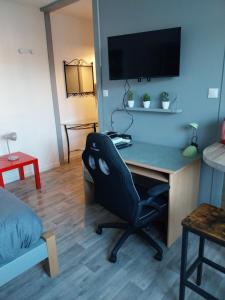Camera con scrivania, sedia e TV. di Studio Beauséjour a Niort