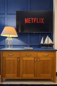 un tavolo con una lampada e un cartello su un muro di The Plaza, King 1 Bedroom Suite by The Hive WA1 a Warrington