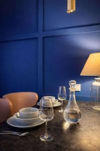 un tavolo con due bicchieri da vino e un vaso di The Plaza, King 1 Bedroom Suite by The Hive WA1 a Warrington