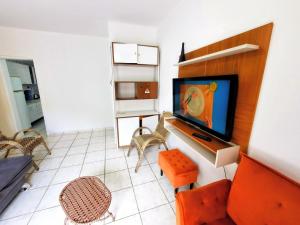 ein Wohnzimmer mit Fernseher und Sofa in der Unterkunft Apartamento na Sepé em Capão da canoa in Capão da Canoa