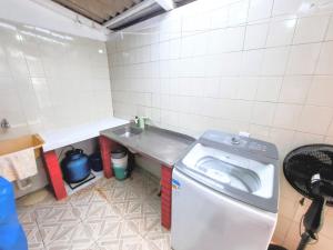 ein kleines Badezimmer mit Waschmaschine und Waschbecken in der Unterkunft Apartamento na Sepé em Capão da canoa in Capão da Canoa + 14 Fotos