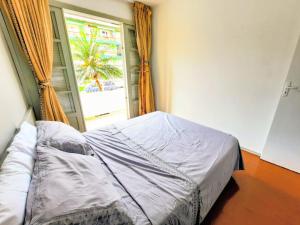 ein Bett in einem Zimmer mit einem Fenster in der Unterkunft Apartamento na Sepé em Capão da canoa in Capão da Canoa