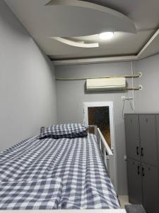 a bedroom with a bed with a blue checkered blanket at Хостел Ганга in Tashkent +31 photos