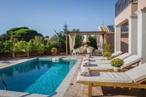 a swimming pool in a backyard with chairs and a table at Anesis by Vintage Travel in Fiskardo