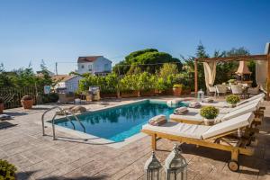 ein Pool mit einem Tisch und Stühlen daneben in der Unterkunft Anesis in Vasilikiádhes