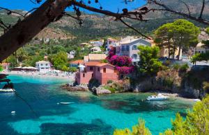 a village on a river with boats in the water at Anesis by Vintage Travel in Fiskardo
