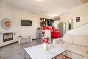 een woonkamer met een witte bank en een tafel bij Spa Villa Sunny in Hanioti