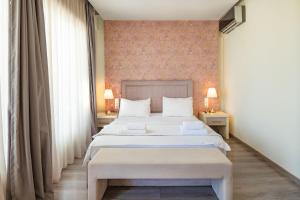 een slaapkamer met een groot wit bed en twee lampen bij Spa Villa Sunny in Hanioti +17 foto's