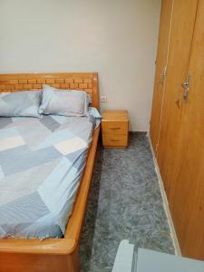 een slaapkamer met een bed naast een houten deur bij Studio meublé prestige in Niamey +44 foto's