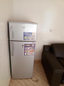 een koelkast in een kamer naast een bank bij Studio meublé prestige in Niamey