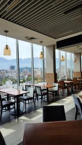 a dining room with tables and chairs and windows at Hyatt Place Santiago/Vitacura in Santiago