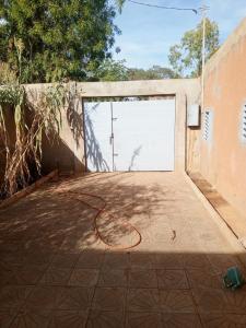 een open garagedeur met een slang op de grond bij Studio meublé prestige in Niamey