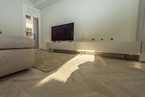 een woonkamer met een bank en een flatscreen-tv bij Dune Luxury Residence in Turijn