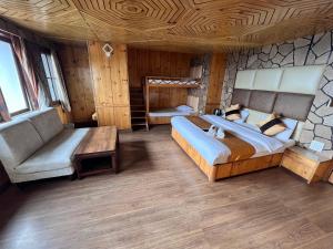 una grande camera da letto con un grande letto e un divano di Hotel Super V mountain homestay a Shimla