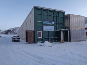 a building with a car parked in the snow at Hotel Arctic Circle in Kangerlussuaq