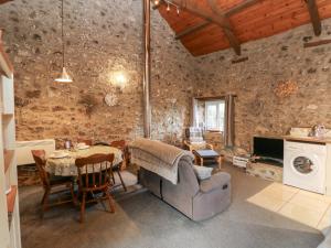 een woonkamer met een tafel en een bank bij 8 Rogeston Cottages in Nolton