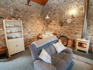 een woonkamer met een bank en een fornuis bij 8 Rogeston Cottages in Nolton