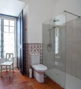 een badkamer met toilet en glazen douche bij Palácio Ficalho in Bicas