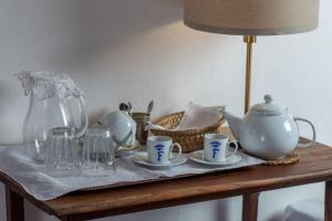 een tafel met kopjes, een theepot en een lamp bij Palácio Ficalho in Bicas