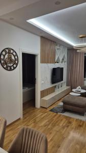 a living room with a clock on the wall at Apartman VIS in Arandjelovac
