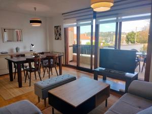 a living room with a television and a table and chairs at La Casuca del Pas - dúplex con terrazas y vistas in Puente Arce