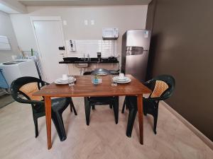 einen Esstisch mit Stühlen und einen Kühlschrank in der Unterkunft Centro 15 in Belo Horizonte + 13 Fotos