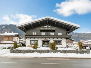 a large building with snow on the ground at FamilienLodge Reith in Reith bei Kitzbühel