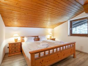 a bedroom with a large bed with a wooden ceiling at FamilienLodge Reith in Reith bei Kitzbühel