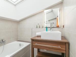 a bathroom with a sink and a bath tub at FamilienLodge Reith in Reith bei Kitzbühel +18 photos