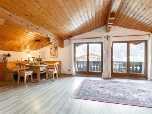 a dining room with a table and chairs and windows at FamilienLodge Reith in Reith bei Kitzbühel