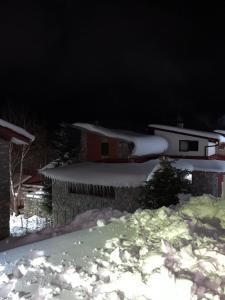 een huis met sneeuw op het dak 's nachts bij Villa 155 in Popova Shapka +4 foto's
