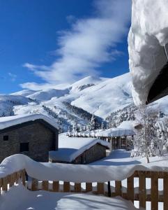een met sneeuw bedekte berg met een gebouw en een besneeuwde helling bij Villa 155 in Popova Shapka