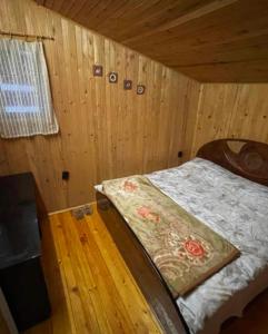 een slaapkamer met een bed in een houten hut bij Villa 155 in Popova Shapka