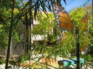 Un adorno de mariposa colgando de un árbol. en Pupa House Hotel, en Tamarindo