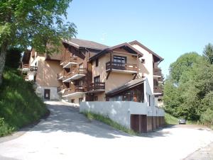 een groot appartementencomplex met een weg ervoor bij APPARTEMENTS MORILLON Village in Morillon