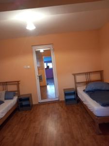 ein Zimmer mit zwei Betten und einem Spiegel in der Unterkunft Liliacului in Marghita + 2 Fotos