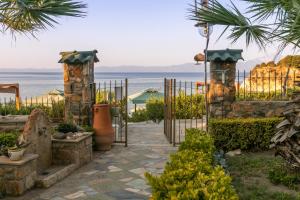 a garden with a gate and the ocean in the background at Talizeti Home - Adults Only in Sarti