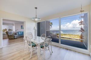 una sala da pranzo con tavolo e vista sull'oceano di Lighthouse Point 228- Stunning Beachside Residence a Sanibel