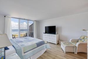 una camera da letto con un letto, una televisione e un balcone di Lighthouse Point 228- Stunning Beachside Residence a Sanibel Altre 6 foto