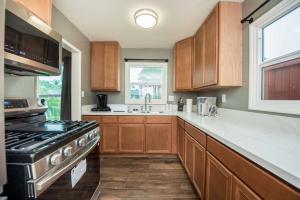 een keuken met houten kasten en een kookplaat met oven bij Welcome to your home at the Orange Circle in Orange