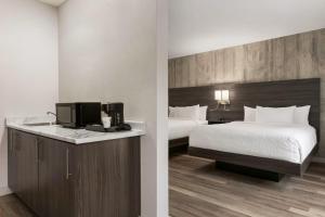 a hotel room with a bed and a tv at Days Inn by Wyndham Saint John in Saint John