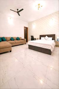 a large bedroom with a bed and a couch at A2 Villa by JMD - Peaceful Stay Near Expo Mart in Greater Noida